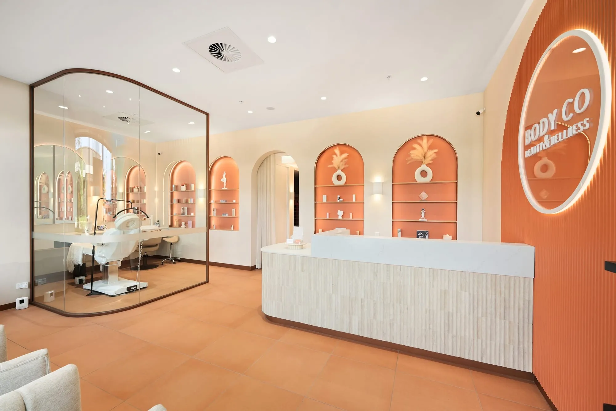 Body Co reception with fluted counter, arched shelving and illuminated sign, Oran Park