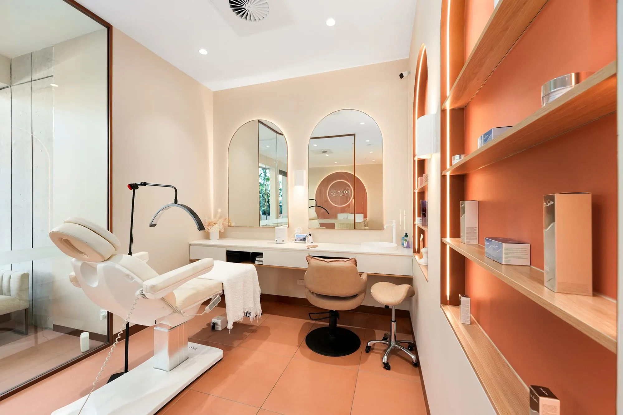 Treatment room with arched mirror and terracotta shelving at Body Co, Oran Park