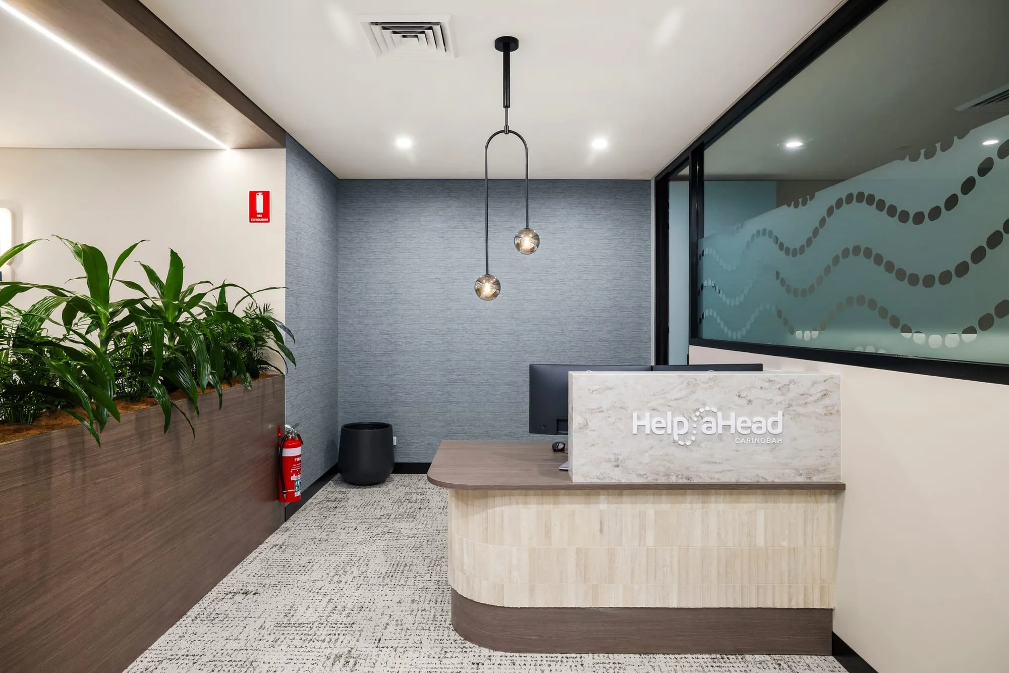 Reception at HelpAhead, Caringbah, with timber planter joinery and a blue feature wall
